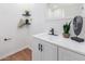 Bright bathroom vanity with white cabinetry, sleek faucet, and decorative accents at 3733 W Flynn Ln, Phoenix, AZ 85019