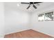 This bedroom offers wood floors, a ceiling fan, natural light from a window, and white walls at 3733 W Flynn Ln, Phoenix, AZ 85019