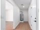 Hallway featuring wood floors, white walls, lighting, and an entrance into another room at 3733 W Flynn Ln, Phoenix, AZ 85019