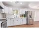 Well-lit kitchen with white cabinetry, stainless steel refrigerator, and modern fixtures at 3733 W Flynn Ln, Phoenix, AZ 85019