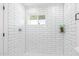 Shower featuring white subway tile, mosaic floor, and glass shelving at 3733 W Flynn Ln, Phoenix, AZ 85019