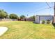 Large backyard with well-maintained lawn, mature trees, block fencing, and a storage shed at 4713 E Cambridge Ave, Phoenix, AZ 85008