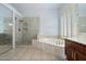Bright bathroom featuring a soaking tub, glass shower, and plantation shutters at 5005 E Baker Dr, Cave Creek, AZ 85331