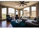 Bright living room featuring a sectional sofa, blue rug, hardwood floor, and chairs by the windows at 5350 E Deer Valley Dr # 4239, Phoenix, AZ 85054