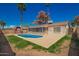 A sparkling pool nestled in a spacious backyard complements a red shed and mature trees, offering a serene outdoor space at 5421 W Seldon Ln, Glendale, AZ 85302