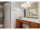 Bright bathroom featuring a wood vanity, large mirror, and shower with a glass door at 5421 W Seldon Ln, Glendale, AZ 85302