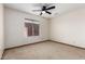Bedroom featuring neutral walls and carpet, a ceiling fan, and a bright window at 5421 W Seldon Ln, Glendale, AZ 85302