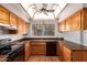 Bright kitchen features wood cabinets, dark countertops, black appliances and a window at 5421 W Seldon Ln, Glendale, AZ 85302