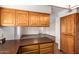 Well-equipped kitchen featuring ample wood cabinets, dark countertops, and an open layout with sightlines to living area at 5421 W Seldon Ln, Glendale, AZ 85302