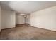 Spacious living room with neutral carpeting, seamlessly connecting different areas of the home at 5421 W Seldon Ln, Glendale, AZ 85302