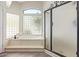 Bright bathroom showcasing a modern bathtub with a glass block window at 5428 W Wethersfield Dr, Glendale, AZ 85304