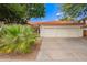 Charming single-story home with a two-car garage, beautiful desert landscaping, and a classic red tile roof at 5428 W Wethersfield Dr, Glendale, AZ 85304