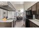 Kitchen with a breakfast bar, stainless steel appliances, dark cabinetry, and modern lighting fixtures at 5428 W Wethersfield Dr, Glendale, AZ 85304