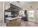 Well-lit kitchen with stainless steel appliances, sleek black cabinetry, and a kitchen island with stone accents at 5428 W Wethersfield Dr, Glendale, AZ 85304