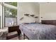 Well-lit bedroom with a large window, side table, and neutral tones at 5428 W Wethersfield Dr, Glendale, AZ 85304