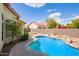 Inviting backyard pool with a stone patio offers a tranquil retreat for relaxation and outdoor enjoyment at 5428 W Wethersfield Dr, Glendale, AZ 85304