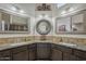 Spacious bathroom featuring granite countertops, decorative mirrors, dual sinks, and a corner layout at 5900 W Orchid Ln, Chandler, AZ 85226