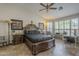 Comfortable primary bedroom with ceiling fan, plantation shutters and a desk area by the window at 5900 W Orchid Ln, Chandler, AZ 85226