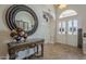 Elegant foyer featuring tile flooring, a decorative table with a mirror, and a front door with glass panels at 5900 W Orchid Ln, Chandler, AZ 85226
