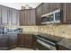 Kitchen close-up featuring stainless steel appliances, granite countertop, and wooden cabinetry at 5900 W Orchid Ln, Chandler, AZ 85226