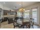 Open kitchen showcasing dark wood cabinets, granite countertops, island, and adjacent dining area with chandelier at 5900 W Orchid Ln, Chandler, AZ 85226