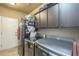 Functional laundry room with modern appliances and ample cabinet space at 5900 W Orchid Ln, Chandler, AZ 85226