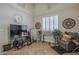 Living room featuring vaulted ceiling, patterned window shutters, TV, clock, and decorative mirrors at 5900 W Orchid Ln, Chandler, AZ 85226