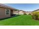 Expansive backyard with artificial turf, a covered patio, and lush landscaping for easy maintenance at 672 S Porter St, Gilbert, AZ 85296
