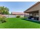 Large backyard featuring green artificial grass and a covered patio perfect for relaxing outdoors at 672 S Porter St, Gilbert, AZ 85296