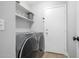 Efficient laundry room features a Whirlpool washer and dryer with overhead shelving at 672 S Porter St, Gilbert, AZ 85296