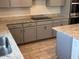 Close-up of the kitchen showing granite counters, gray cabinets, and stainless appliances at 7227 N 125Th Dr, Glendale, AZ 85307