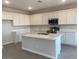 Modern kitchen with stainless steel appliances, a large island, and white cabinets, perfect for cooking and entertaining at 7244 E Hackamore Ln, San Tan Valley, AZ 85143