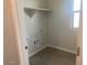 Neutral-toned laundry room offers storage with open shelving, a utility sink, and natural light at 7244 E Hackamore Ln, San Tan Valley, AZ 85143