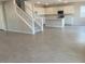 Spacious living room showcasing durable, light-toned tile flooring, a staircase, and an open-concept kitchen at 7244 E Hackamore Ln, San Tan Valley, AZ 85143