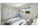 Staged bedroom features a large window, an area rug, a blue accent chair and lots of closet space at 7502 E Princeton Ave, Scottsdale, AZ 85257