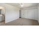 Unstaged bedroom offers a blank canvas with white walls, neutral carpet, and a closet area leading to the bathroom at 7502 E Princeton Ave, Scottsdale, AZ 85257