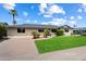 Well-maintained front yard with green grass, palm trees, and a long driveway leading to the house at 7502 E Princeton Ave, Scottsdale, AZ 85257