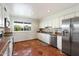 Bright kitchen featuring white cabinets, stainless steel appliances, terra-cotta flooring and a window view at 7502 E Princeton Ave, Scottsdale, AZ 85257
