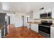 Bright kitchen with stainless steel oven and microwave and white cabinetry. Adjacent to breakfast nook at 7502 E Princeton Ave, Scottsdale, AZ 85257