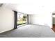 Spacious living room with a gray carpet, large window, and a clean, minimalist aesthetic at 7502 E Princeton Ave, Scottsdale, AZ 85257