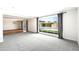 Bright living room featuring neutral décor, large window, gray carpet, and view of the backyard pool at 7502 E Princeton Ave, Scottsdale, AZ 85257