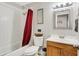 Bright bathroom featuring a shower-tub combo with red curtain and a wooden vanity with white countertop at 7520 E Papago Dr, Scottsdale, AZ 85257
