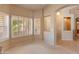 Bright bedroom with carpet flooring, plantation shutters, and neutral paint, leading to other rooms via an arched doorway at 7916 W Mary Ann Dr, Peoria, AZ 85382