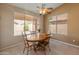 Cozy dining area with natural light, a ceiling fan, and a wood table set at 7916 W Mary Ann Dr, Peoria, AZ 85382