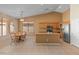 Kitchen and dining area featuring tiled floors, wooden cabinets, granite countertops, and natural light through window at 7916 W Mary Ann Dr, Peoria, AZ 85382