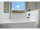 Inviting bathtub featuring a sleek design and a serene window view at 881 W Saragosa St, Chandler, AZ 85225