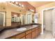 Bathroom featuring a double vanity with granite countertops and a large mirror at 9039 E Winchcomb Dr, Scottsdale, AZ 85260