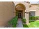 Inviting arched entryway with lush greenery leading to the front door at 9039 E Winchcomb Dr, Scottsdale, AZ 85260