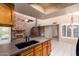 Open-concept kitchen featuring granite countertops, oak cabinets, stainless steel appliances, and a brick fireplace at 9039 E Winchcomb Dr, Scottsdale, AZ 85260