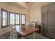 Dining area featuring a wooden table, seating for six, bay windows with wooden shutters, and a refrigerator at 907 N Mountain Rd, Mesa, AZ 85207